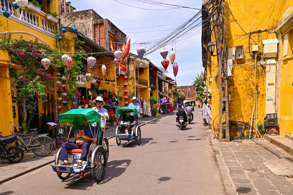 Cyclos on a lantern-lined street in Hoi An, Vietnam